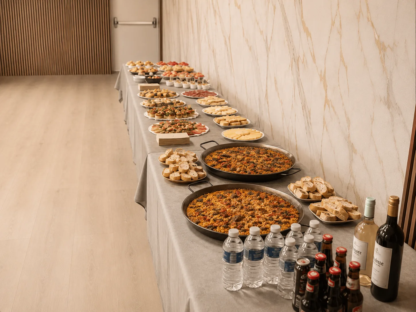 Mesa de catering con paellas, aperitivos y bebidas en Espacio I3J