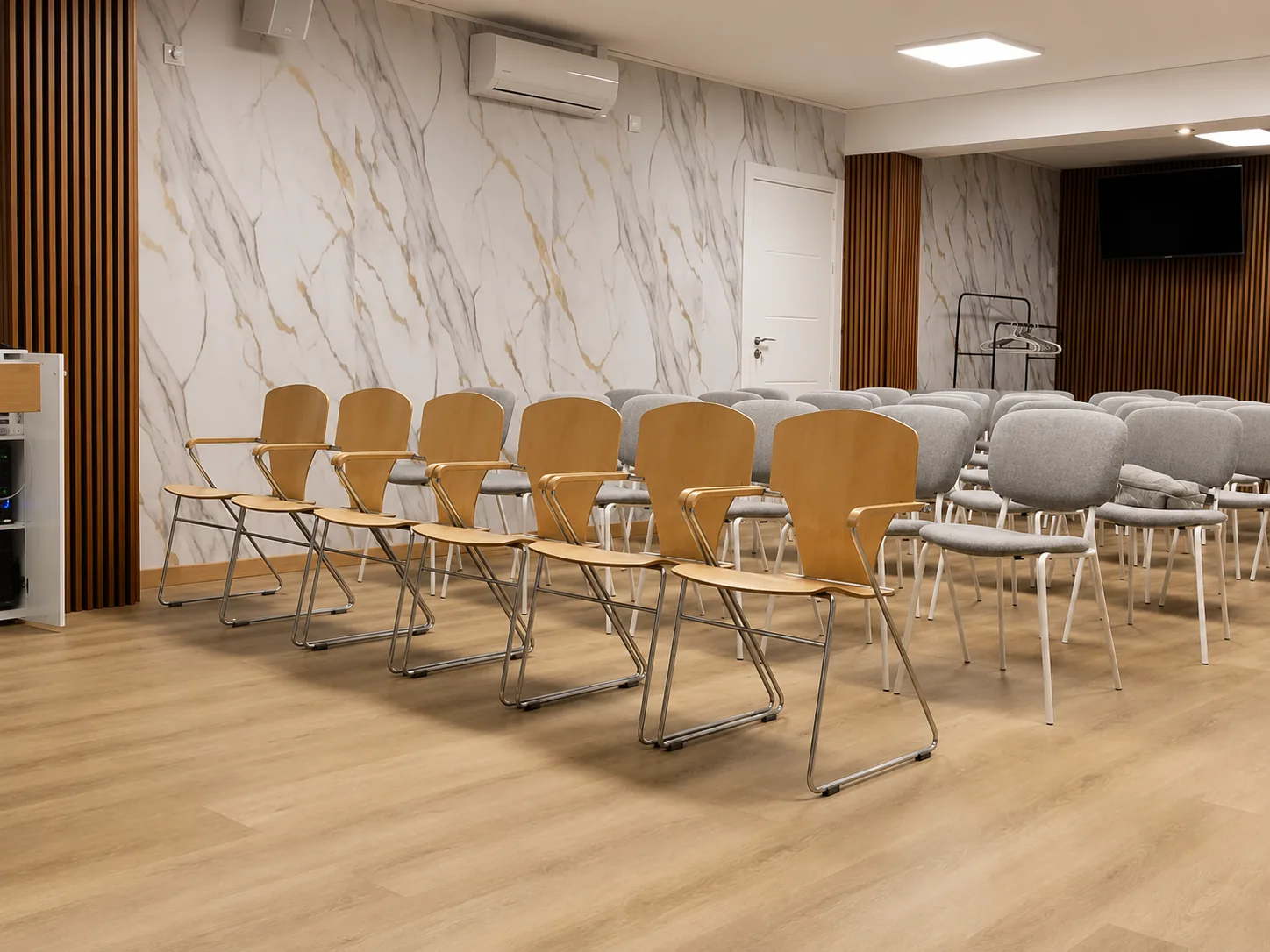 Salón con pared de mármol y veta dorada, formato auditorio
